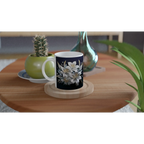 Ceramic mug with floral design on table with books and plants