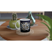 Ceramic mug with floral design on table with books and plants