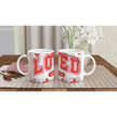 White ceramic mugs with red and pink geometric designs, on a checkered tablecloth with a pink napkin and wooden spoon