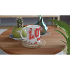 White mug with red lettering on wooden table